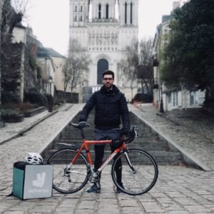 Photo de Maxime de Deliveroo devant son vélo