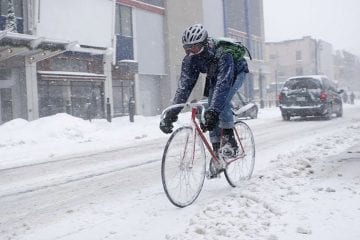 Un coursier à vélo avec le bon équipement dans le froid de l'hiver