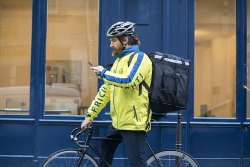 Un livreur Frichti en vélo consultant son smartphone