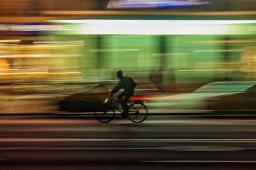 Photo d'un livreur dans le flou sur son vélo pour illustrer le débat "Coursier à vélo: salarié ou micro-entrepreneur ?"